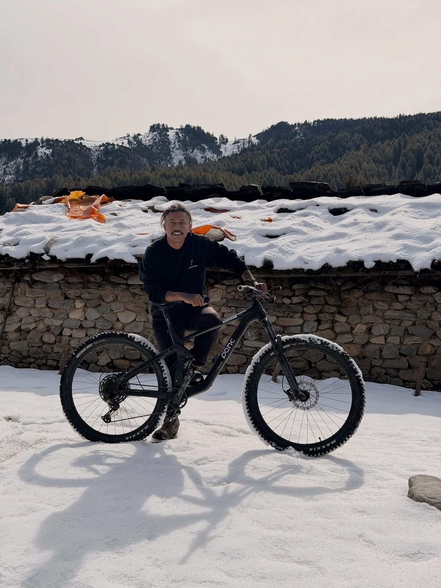 Leaning on a black mountain bike in snowy village