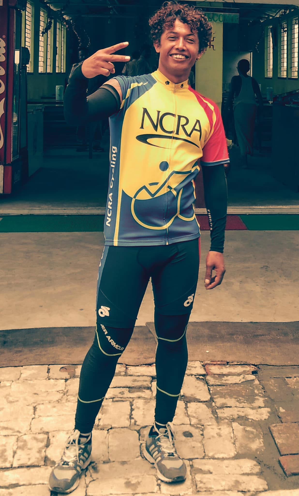Young Ajit in NCRA cycling kit, peace sign