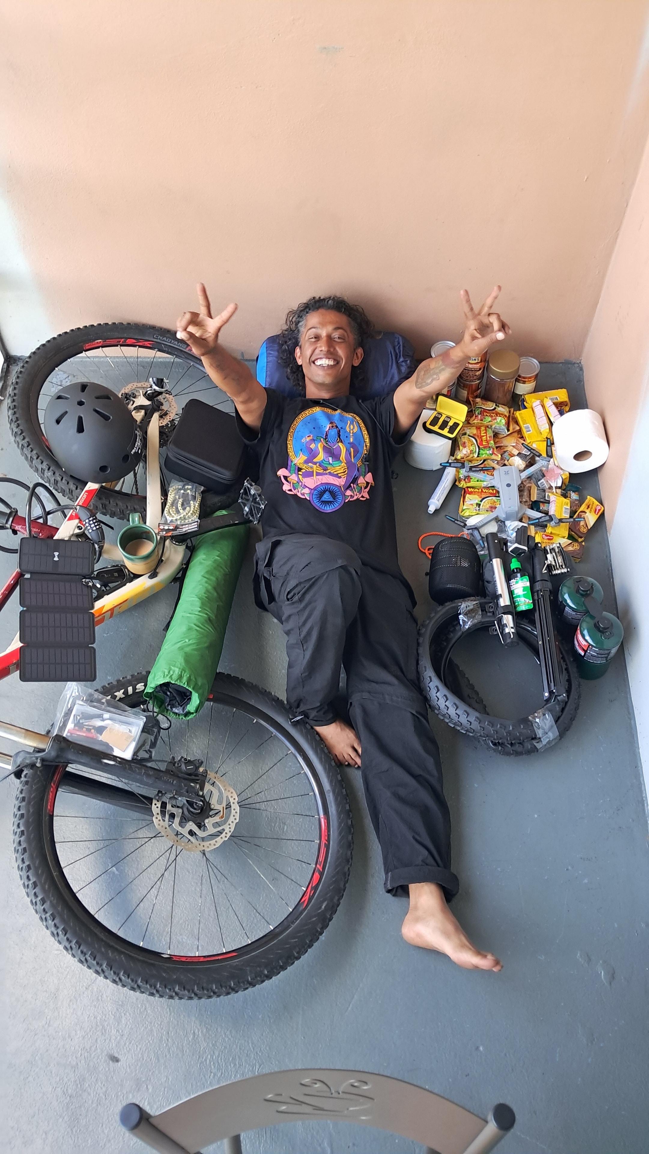 Man surrounded by camping and cycling gear